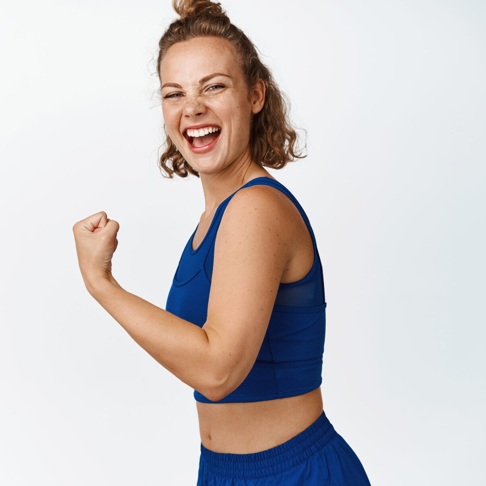 Enthusiastic fitness woman shows strong arm, flexing miceps and shows muscles, gym workout results, healthy body, standing over white background.