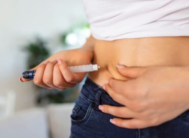 A diabetic patient using insulin pen for making an insulin injection at home. Young woman control diabetes. Diabetic lifestyle